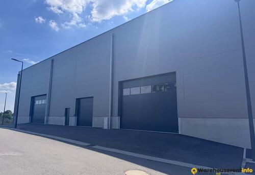 Modern facade featuring large sectional doors (H 3.5m to 4.5m) and heavy vehicle access.